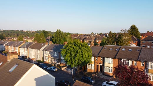 Aerial view of a suburban neighborhood under a clear sky, representing insights into property and credit markets.