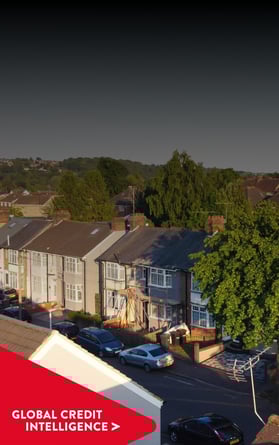 Aerial view of a suburban neighborhood under a clear sky, with a red banner overlay reading 'Global Credit Intelligence,' representing insights into property and credit markets.
