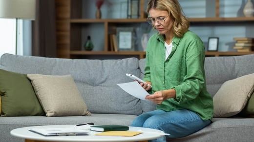 Woman looks at her financial expenses with worry.