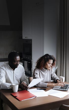 Couple reviews their expenses with serious expressions