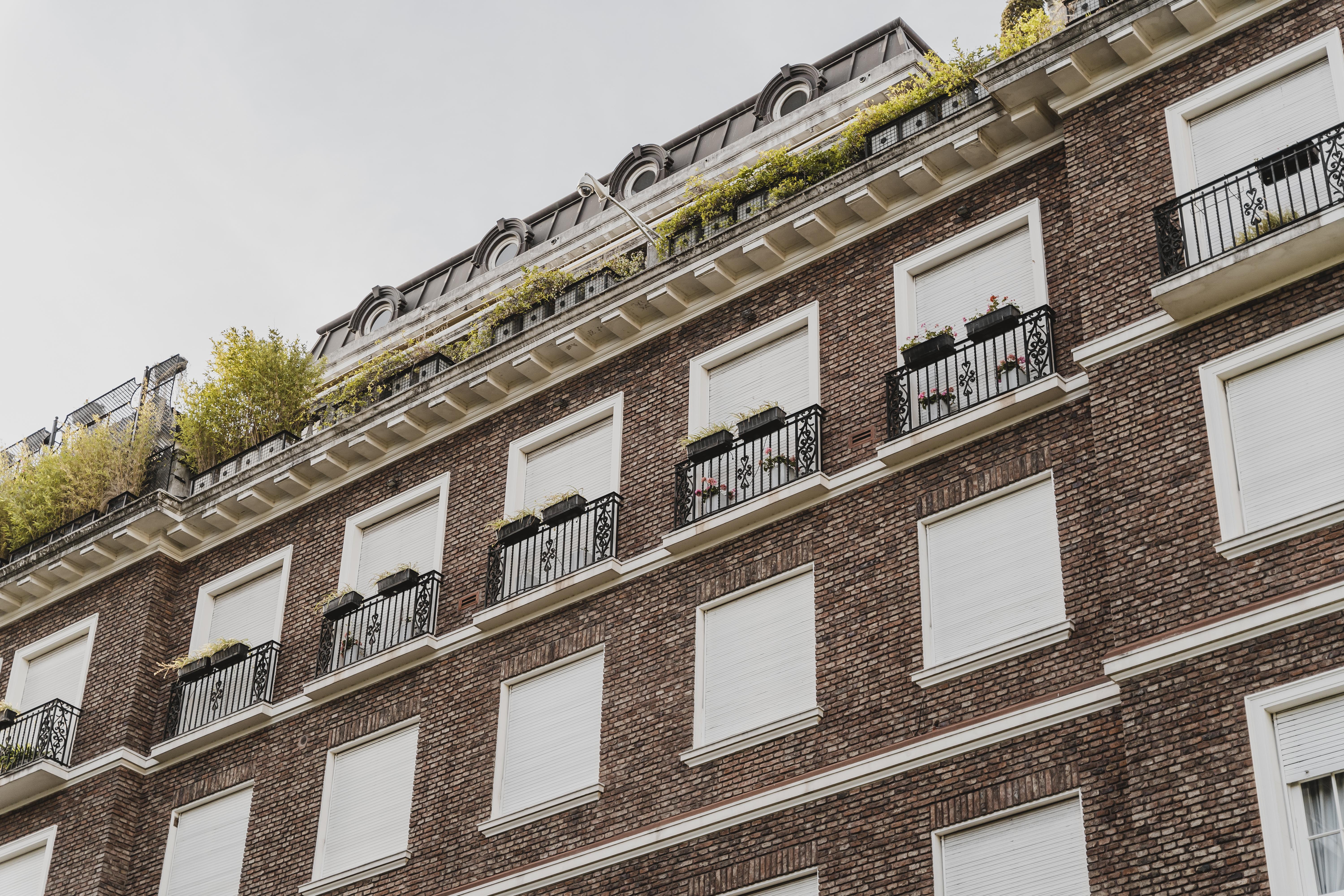 Modern brick commercial building with closed shutters and structured balconies, symbolizing financial stability and trust—core values in credit intelligence services.