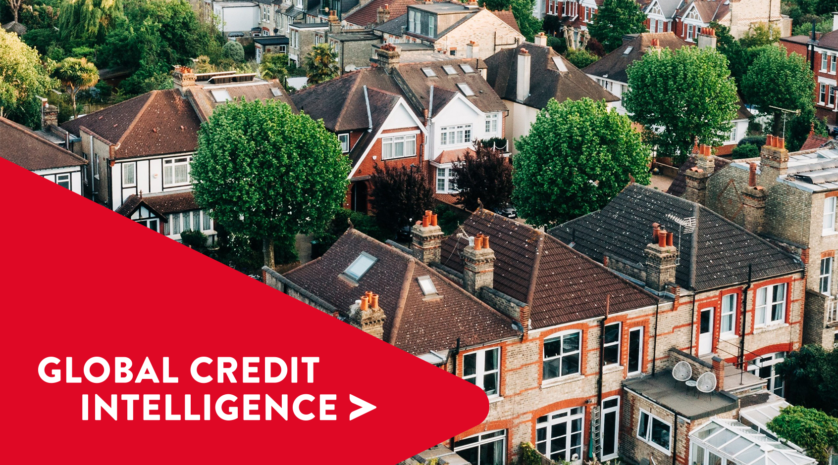 Aerial view of suburban UK housing, illustrating the residential property market, mortgage lending, and credit risk analysis in the UK mortgage sector by a credit management and technology company with a red global credit intelligence chevron overlaid in bottom left corner.